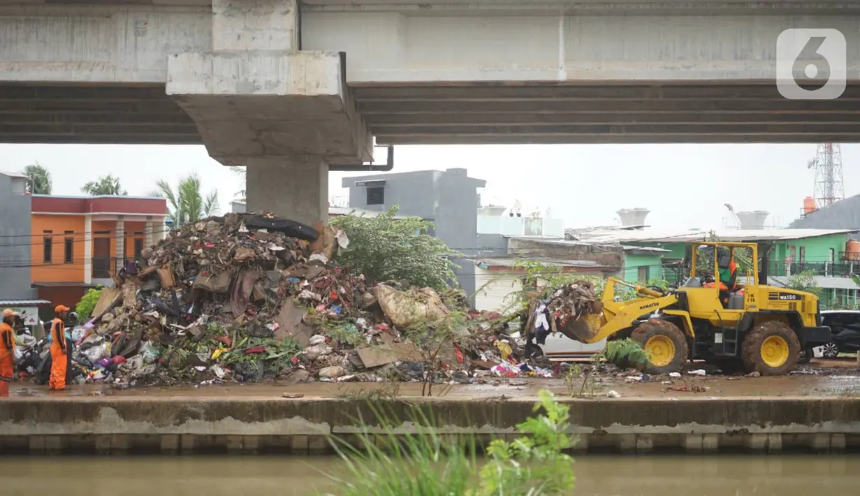 Petugas menggunakan alat berat untuk mengangkut sampah sisa banjir yang menumpuk di kawasan Cipinang Melayu, Jakarta, Senin (6/1/2020). Banjir yang menggenangi Jakarta dan sekitarnya sejak 1 Januari 2020 lalu menyisakan tumpukan sampah di sejumlah titik. (Liputan6.com/Immanuel Antonius)