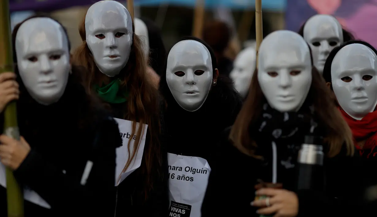 Demonstran mengenakan topeng saat unjuk rasa menentang kekerasan gender di Buenos Aires, Argentina, Sabtu (3/6). Demonstran menuntut agar pemerintah mengambil tindakan tegas terhadap pelaku kekerasan gender. (Foto AP / Natacha Pisarenko)