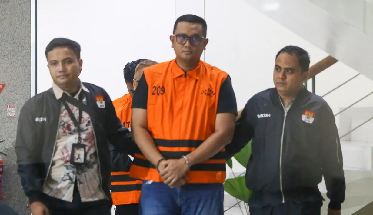 Petugas mengawal Bupati Klaten Hamenang Wajar Ismoyo menuju mobil tahanan di Gedung Merah Putih KPK, Jakarta, Jumat (16/10/2026). Dalam perkara ini, KPK juga menetapkan dua orang lainnya sebagai tersangka dan menyita barang bukti uang tunai sekitar Rp1,9 miliar. (KLY/Budy Santoso)