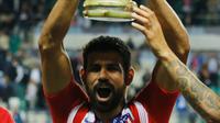 Penyerang Atletico Madrid, Diego Costa mengangkat Piala Super Eropa usai pertandingan melewan Real Madrid di Lillekula Stadium di Tallinn, Estonia, (15/8). Atletico Madrid berhasil mengalahkan Real Madrid dengan skor telak 4-2. (AP Photo/Pavel Golovkin)