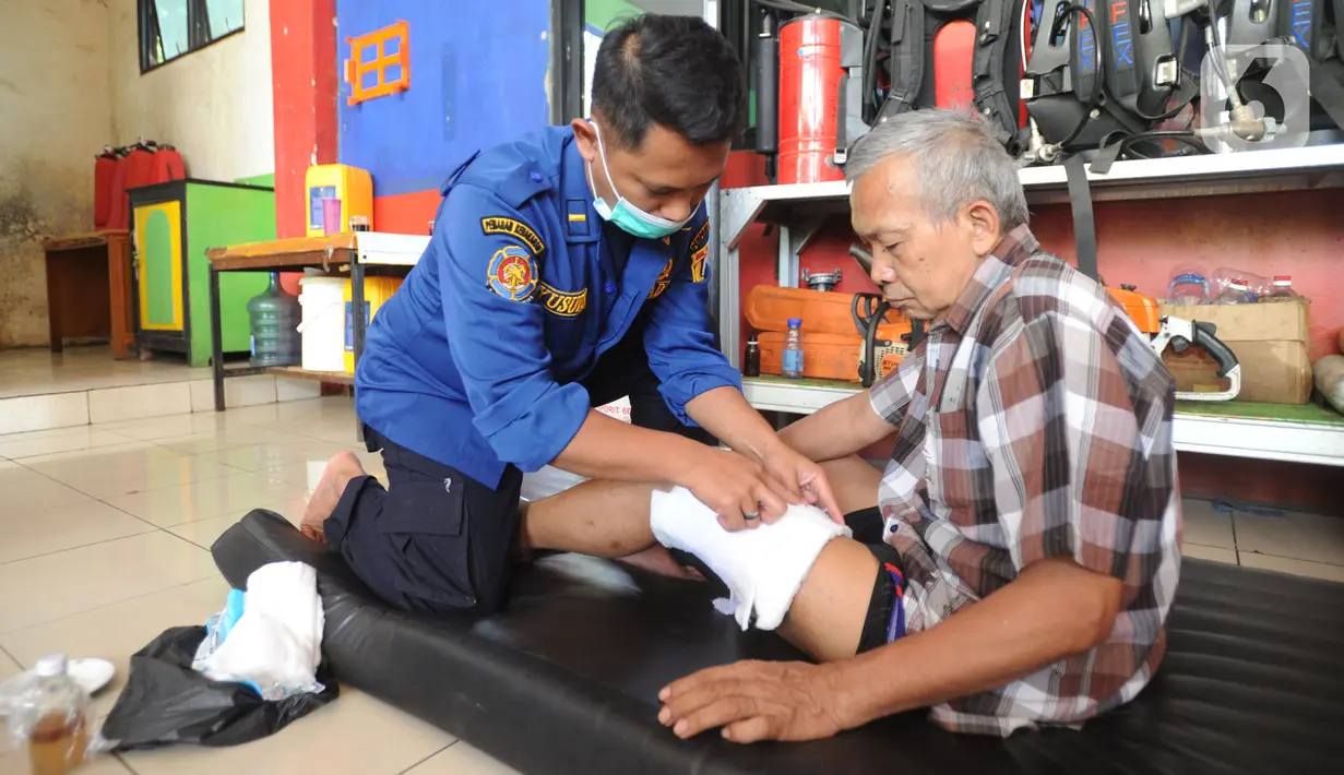 Seorang warga saat dipijat oleh petugas Damkar di Pos Damkar Ciganjur, Jagakarsa, Jakarta Selatan, Rabu (02/12/2020). Petugas Damkar memijat khas Cimande dengan bayaran seikhlasnya, pengobatan dilakukan di sela waktu senggang petugas Damkar. (merdeka.com/Arie Basuki)