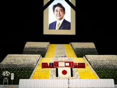 Potret mantan Perdana Menteri Jepang Shinzo Abe terlihat pada altar saat pemakaman kenegaraannya di Nippon Budokan, Tokyo, Jepang, 22 September 2022. Prosesi diawali dengan pemberian sambutan dari Wakil Ketua Panitia Pelayanan Pemakaman dan dilanjutkan dengan pengumandangan Lagu Kebangsaan Jepang. (Franck Robichon/Pool Photo via AP)