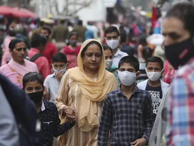 Warga India yang mengenakan masker berbelanja di Sunday market di Jammu, India, Minggu (21/3/2021). India sedang menghadapi gelombang baru infeksi Covid-19 dan mencatat rekor lonjakan harian tertinggi dalam hampir empat bulan terakhir. (AP Photo/Channi Anand)