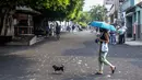 Orang-orang berjalan di jalan yang tertutup abu dari gunung berapi di Pulau Canary La Palma, di Los Llanos de Aridane, Spanyol (1/10/2021). Pihak berwenang tengah mengawasi untuk melihat apakah lava dari celah baru akan bergabung dengan aliran utama yang telah mencapai laut. (AP Photo/Saul Santos)