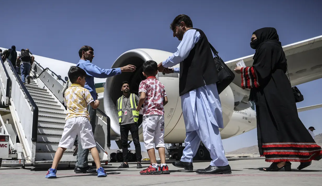 Penumpang berdiri dalam antrean untuk menaiki pesawat Pakistan International Airlines (PIA) di bandara di Kabul, Senin (13/9/2021). Pesawat itu tercatat sebagai penerbangan komersial internasional pertama yang mendarat sejak Taliban merebut kembali kekuasaan di Afghanistan. (Karim SAHIB/AFP)