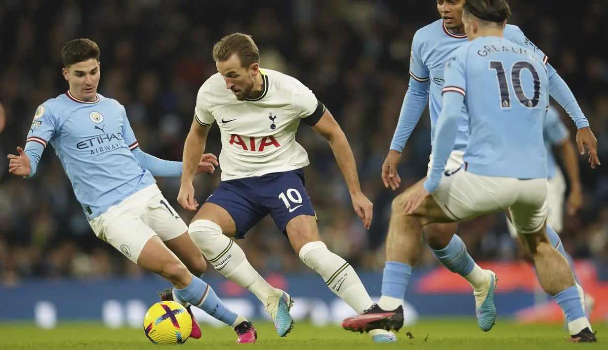 Pemain Tottenham Hotspur, Harry Kane, berusaha melewati pemain Manchester City pada laga Liga Inggris di Stadion Etihad, Kamis (19/1/2023). (AP Photo/Dave Thompson)