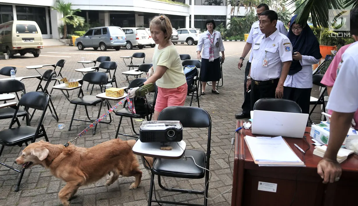 Warga membawa anjing peliharaannya saat Sinkronisasi Data Rabies Melalui Aplikasi 'SIRaJa: Sistem Informasi Rabies Jakarta' di Kantor Dinas Ketahanan Pangan, Kelautan, dan Pertanian (KPKP), Jakarta, Rabu (12/9). (Merdeka.com/Iqbal Nugroho)