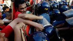 Demonstran berhadapan dengan polisi anti huru-hara ketika aksi protes pada May Day 2016 atau Hari Buruh Sedunia di depan Kedutaan Besar AS di Manila, Filipina, Minggu (1/5). (REUTERS/Czar Dancel)