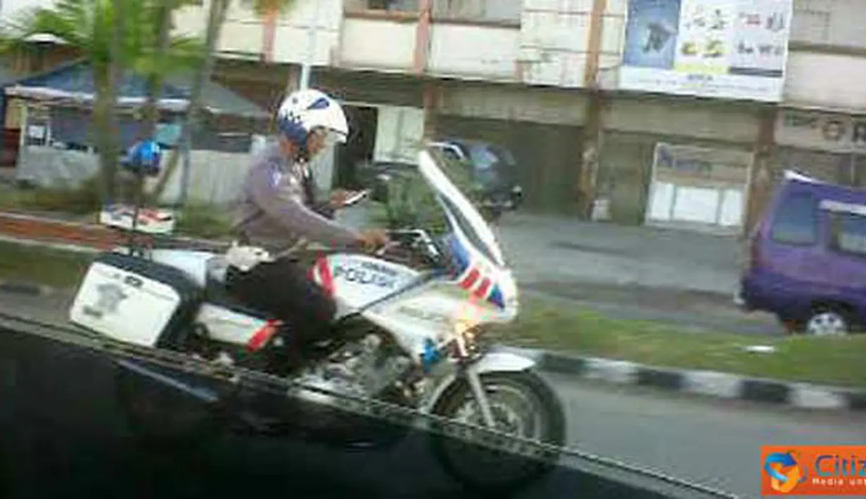 Citizen6: Polisi mengendarai motor sambil SMS, tindakan yang tidak patut dicontoh karena akan membahayakan pengendara lainnya. (Pengirim: Masterphone)