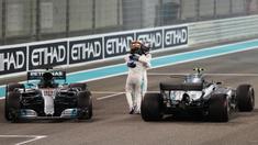 Pebalap Mercedes, Lewis Hamilton (depan) dan rekannya Valtteri Bottas merayakan keberhasilan masuk finis pada balapan F1 Abu Dhabi di Yas Marina circuit , (26/11/2017). Bottas finis pertama. (AFP/Karim Sahib)