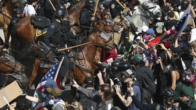 Demonstran yang terlibat dalam aksi protes "No Kings" berhadapan dengan penegak hukum yang menunggang kuda pada Sabtu, (14/6/2025), di Los Angeles, California, Amerika Serikat.