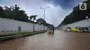 Sebuah truk melintasi banjir yang menggenangi Jalan Tol JORR di kawasan TB Simatupang, Jakarta Selatan, Sabtu (20/2/2021). Banjir terjadi akibat luapan Kali Serua yang berada di pinggir jalan tol. (merdeka.com/Arie Basuki)