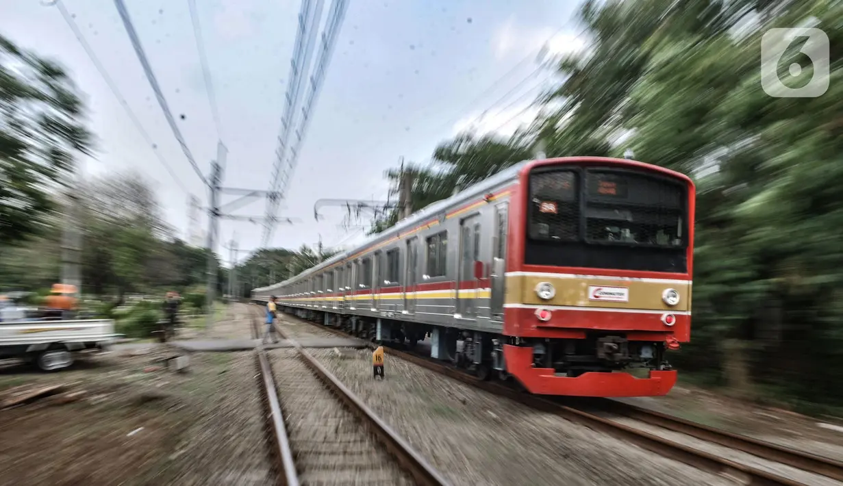 Sebuah KRL saat melintasi perlintasan tanpa palang pintu di kawasan TPU Tanah Kusir, Jakarta, Kamis (17/9/2020). Pemasangan pembatas jalan tersebut dilakukan untuk mencegah kecelakaan kendaraan yang sering terjadi di kawasan tersebut. (merdeka.com/Iqbal S. Nugroho)
