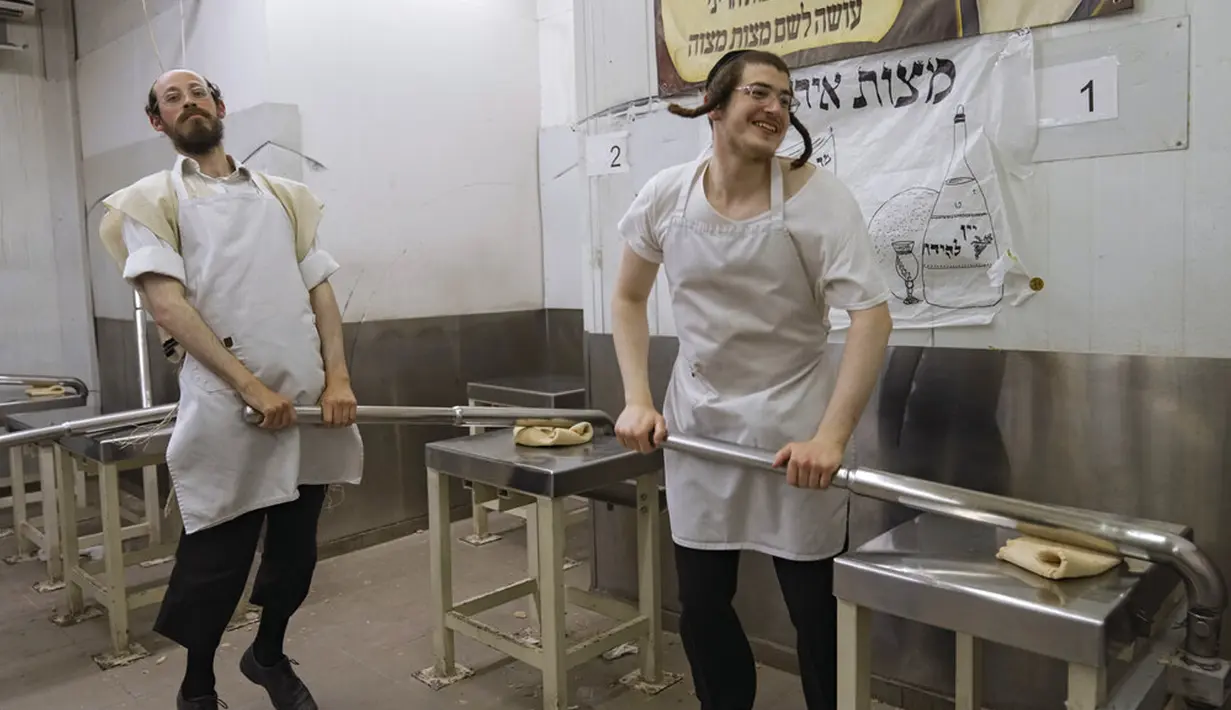 Yahudi Ultra-Ortodoks menyiapkan matzoh khusus di sebuah toko roti di Ashdod, Israel, 11 April 2022. Matzoh adalah roti tradisional tidak beragi yang dibuat untuk Paskah. (AP Photo/Tsafrir Abayov)