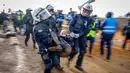 <p>Polisi membawa demonstran untuk membersihkan jalan di Desa Luetzerath dekat Erkelenz, Jerman, 10 Januari 2023. Desa Luetzerath diduduki oleh aktivis iklim yang berjuang melawan penghancuran desa untuk memperluas tambang batu bara Garzweiler dekat perbatasan Belanda. (AP Photo/Michael Probst)</p>