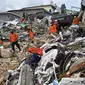 Tim penyelamat mencari korban di sebuah bangunan yang runtuh di kota Mamuju, Sulawesi Barat, Sabtu (16/1/2021). Jalan dan jembatan yang rusak, pemadaman listrik, dan kurangnya alat berat menghambat evakuasi setelah gempa bermagnitudo 6,2 SR yang melanda Majene- Mamuju. (Hariandi Hafid/AFP)