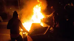 Pengunjuk rasa membakar tempat sampah selama aksi protes berujung kerusuhan di Aulnay-sous-Bois, pinggiran utara kota Paris, Rabu (8/2). Ketegangan tersebut dipicu dugaan penganiayaan dan pemerkosaan oleh seorang polisi terhadap seorang tahanan. (AFP)