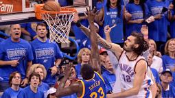 Pemain OKC Thunder, Steven Adams #12 melakukan dunk melewati  pemain Warriors forward Draymond Green #23 pada lanjutan final wilayah barat NBA Playoffs 2016 di Chesapeake Energy Arena, Oklahoma City, (29/5/2016) WIB. (Mark D. Smith-USA TODAY Sports)