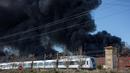 Kereta melintas di dekat perusahaan kimia Indukern yang sedang terjadi kebakaran di kawasan industri Fuente del Jarro, Paterna, Valencia, Spanyol, Rabu (8/2). (AFP PHOTO / Biel Alino)