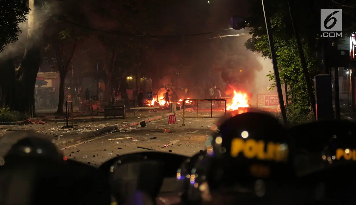 Massa melakukan pembakaran saat mencoba melawan petugas kepolisian di kawasan Tanah Abang, Jakarta, Rabu (22/5/2019). Massa pengunjuk rasa berada di kawasan dekat Blok A Tanah Abang tersebut setelah terus dipukul mundur oleh aparat dari kawasan gedung Baw