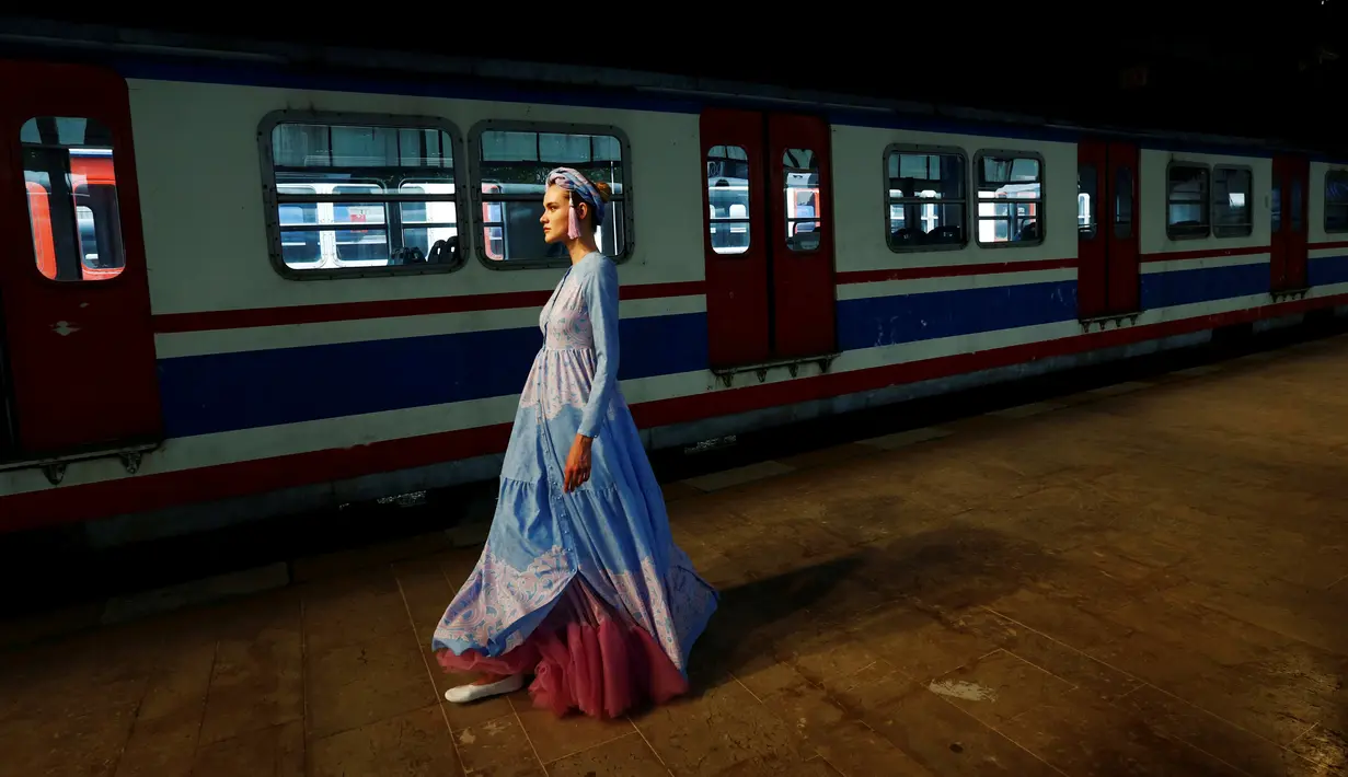 Model berjalan dengan balutan busana muslim khas Turki selama Istanbul Modest Fashion Week di stasiun kereta api Haydarpasa di Istanbul, Turki 13 Mei 2016. (REUTERS / Murad Sezer)