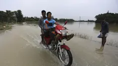Seorang pengendara motor melewati jalan yang banjir di daerah Bagha di Sylhet, Bangladesh (23/5/2022). Banjir bandang pra-musim telah membanjiri bagian dari India dan Bangladesh, menewaskan sedikitnya 24 orang dalam beberapa pekan terakhir dan mengirim 90.000 orang ke tempat penampungan. (AP Photo)