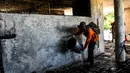 Seorang petugas pemadam kebakaran memadamkan sisa api di dalam Panti Asuhan Church of Bible Understanding, pinggiran Port-au-Prince di ibu kota Haiti, Jumat (14/2/2020). Panti asuhan yang sudah tidak berizin sejak 2013 itu menampung sekitar 66 anak-anak. (CHANDAN KHANNA/AFP)