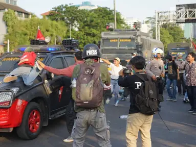 Massa pelajar menyerang kendaraan milik kepolisian yang melintas saat aksi unjuk rasa  di sekitar kawasan DPR RI, Jakarta, Senin (30/9/2019). Sempat terjadi kericuhan akibat peristiwa tersebut hingga menyebabkan jalan tol ditutup. (Liputan6.com/Immanuel Antonius)