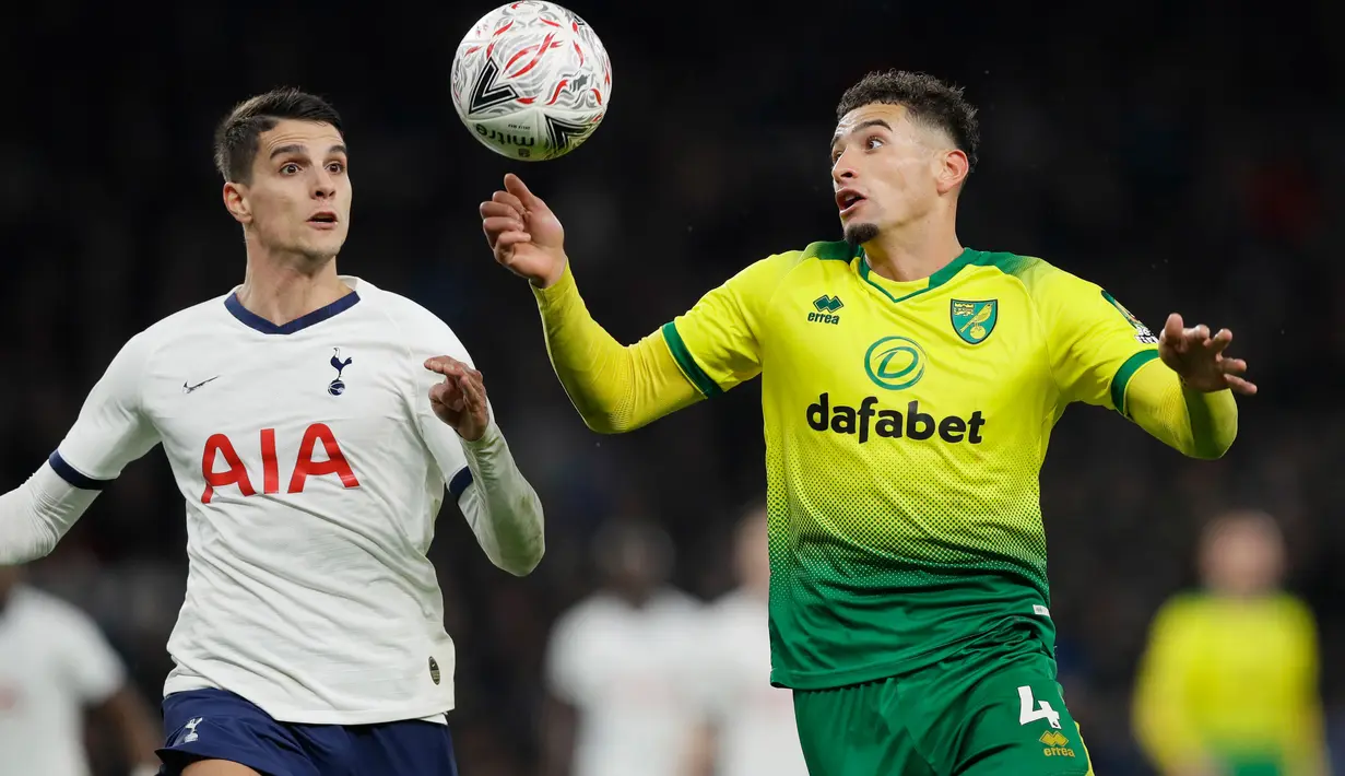 Pemain Norwich City, Ben Godfrey berebut bola dengan penyerang Tottenham Hotspur, Erik Lamela pada putaran kelima Piala FA di Tottenham Stadium, Rabu (4/3/2020). Langkah Tottenham di Piala FA 2019/2020 terhenti setelah kalah adu penalti 2-3 (1-1) dari Norwich. (AP/Kirsty Wigglesworth)