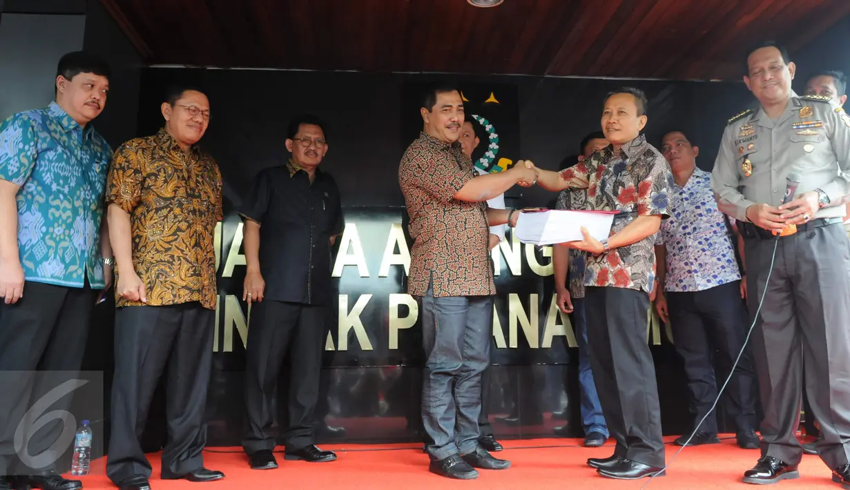 Dirtipidum Bareskrim Polri Brigjen Agus Andrianto (kiri) menyerahkan berkas perkara tahap 1 kepada Ketua Jaksa Peneliti Berkas Perkara Ahok, Ali Mukartono di Kejaksaan Agung, Jakarta, Jumat (25/11). (Liputan6.com/Helmi Afandi)
