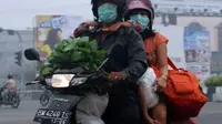 Pengendara sepeda motor mengenakan masker di tengah kabut asap yang menyelimuti Kota Pekanbaru, Riau.Kabut asap dari kebakaran lahan terus mencemari udara dan berpotensi mengganggu kesehatan.(Antara)