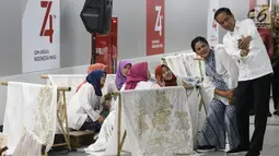 Presiden Joko Widodo dan Ibu Negara Iriana Jokowi  berselfie dengan sejumlah pembatik dalam acara batik kemerdekaan di Stasiun MRT Bundaran HI, Kamis (1/8/2019). Dalam kesempatan tersebut Jokowi berharap batik bisa dikembangkan sebagai sebuah brand. (Liputan6 com/Angga Yuniar)