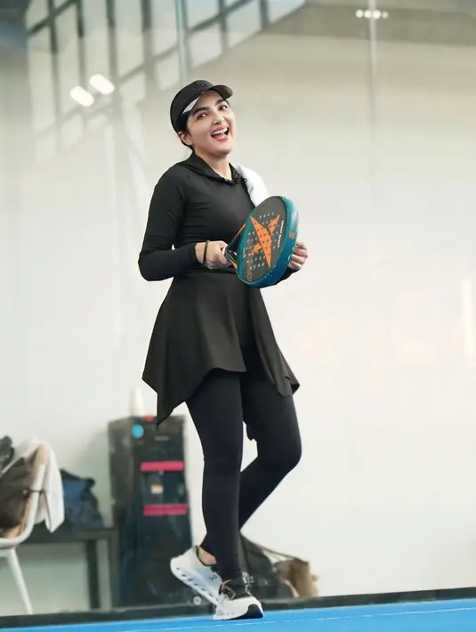 Ashanty juga mengenakan visor hitam bertuliskan logo merek, memberikan perlindungan dari cahaya sekaligus menambah aksen sporty pada look-nya. [@ashanty_ash].