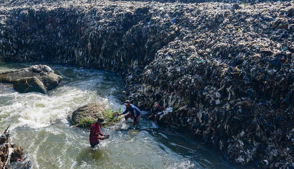 Warga memanfaatkan aliran Kali Pesanggrahan yang menyempit untuk mendulang benda-benda logam di kawasan Pasir Putih, Depok, Jawa Barat, Senin (27/4/2026), setelah longsoran sampah dari Tempat Pembuangan Akhir (TPA) Cipayung menutup sebagian badan sungai. (merdeka.com/Arie Basuki)