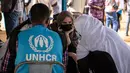 Aktris Angelina Jolie, utusan khusus PBB untuk UNHCR, berbincang dengan pengungsi Mali di kamp Goudebou, utara Burkina Faso, 20 Juni 2021. Jolie mengunjungi kamp pengungsi yang menampung ribuan warga Mali yang menyelamatkan diri dari kekerasan militan di kawasan itu. (OLYMPIA DE MAISMONT/AFP)