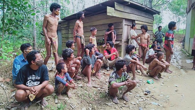 Kelompok orang rimba Jambi di Dusun 24, Kabupaten Batanghari, Jambi, saat mengantre pencairan bantuan sosial tunai, Jumat (17/7/2020). Bantuan tersebut untuk masyarakat kurang mampu terdampak Covid-19. (Liputan6.com/Gresi Plasmanto)