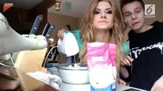Seorang wanita mengalami hal yang kurang menyenangkan saat melakukan tutorial masak. Rambutnya tersangkut alat pengaduk adonan atau mixer.