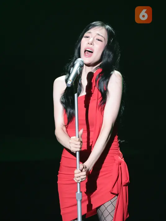 Tiffany Young tampil mengenakan gaun merah, stoking jaring-jaring, dan sepatu bot hitam saat membuka konser Edge of Calm Tour di JIEXPO Theatre Kemayoran, Jakarta, Sabtu (19/9/2026) malam. (KLY/Budy Santoso)