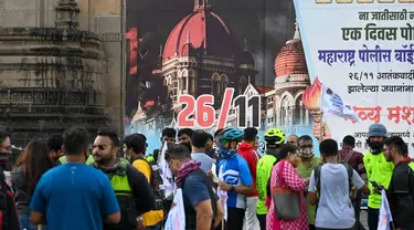 Orang-orang berkumpul di dekat Gerbang India untuk memberikan penghormatan kepada para korban serangan teroris 2008 pada peringatan 13 tahun di Mumbai (26/11/2021). Dalam peringatan itu mereka akan menggelar doa, peletakan karangan bunga, dan melakukan aksi damai. (AFP/Punit Paranjpe)