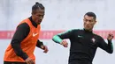 Bek Portugal, Bruno Alves berebut bola dengan Cristiano Ronaldo saat latihan di Kratovo, Moskow (10/6). Bek 36 tahun ini menjalani laga ke-100-nya di Piala Dunia 2018 ini.  Saat ini Alves bermain di Rangers FC. (AFP Photo/Francisco Leong)