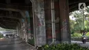 Pengendara motor melintasi sisi tiang penyangga Jalan Tol Pelabuhan Lingkar Dalam Jakarta di Jalan Ancol Timur, Jakarta, Selasa (16/6/2020). Seni mural yang dulu menghiasi tiang-tiang jalan tol di kawasan tersebut kini terlihat kusam dan berdebu. (Liputan6.com/Helmi Fithriansyah)