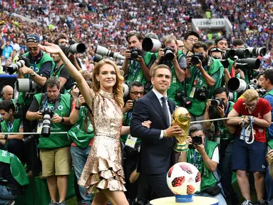 Mantan kapten Jerman Philipp Lahm (kanan) dan model Rusia Natalia Vodianova (kiri) menyapa penonton dengan membawa trofi Piala Dunia pada penutupan Piala Dunia 2018 Rusia di Stadion Luzhniki, Moskow (15/7). (AFP Photo / Franck Fife)