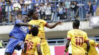 Striker Persib, Ezechiel Ndouassel, duel udara dengan bek Sriwijaya FC, Bio Paulin, pada laga Piala Presiden di Stadion GBLA, Bandung, Selasa (16/1/2018). Persib menang 1-0 atas Sriwijaya FC. (Bola.com/M Iqbal Ichsan)
