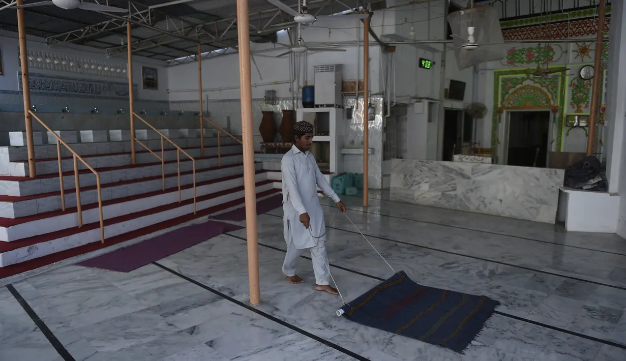 Seorang anak laki-laki membersihkan masjid menjelang Ramadan di Karachi, Pakistan pada Sabtu (10/4/2021). Kegiatan membersihkan masjid tersebut  untuk menyambut datangnya bulan suci Ramadan 1442 H. (Rizwan TABASSUM / AFP)