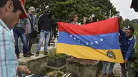 Bendera negara Venezuela dibentangkan saat prosesi pemakaman Jose Francisco Guerrero di San Cristobal, Tachira State, Venezuela (19/5). (AFP/Luis Robayo)