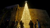 Warga Suriah berkumpul di sekitar pohon Natal di ibu kota Damaskus. (Louai Beshara/AFP)