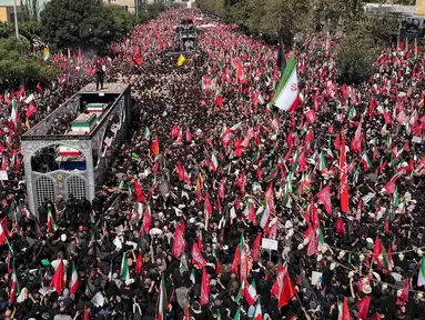 Sebuah truk yang membawa peti jenazah Pemimpin Tertinggi Iran Ayatollah Ali Khamenei dan anggota keluarganya melintas di tengah kerumunan pelayat selama prosesi pemakaman di Teheran, Iran, Senin, 6 Juli 2026. (AP Photo/Vahid Salemi)