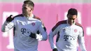 Bek Bayern Munchen Niklas Suele (kiri) dan  rekan setimnya Jamal Musiala melakukan pemanasan selama sesi latihan di Munich, Jerman selatan di Munich, Jerman selatan (7/12/2021). Bayern Munchen akan bertanding melawan Barcelona pada Grup E Liga Champions di di Allianz Arena. (AFP/Christof Stache)