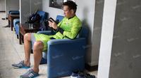 Kiper Persib, I Made Wirawan, asyik bermain ponsel ketika berada di Mess Persib Bandung, Jawa Barat, Senin (2/5/2016). (Bola.com/Vitalis Yogi Trisna)