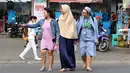 Seorang biarawati bergandeng tangan dengan wanita berkerudung saat menyeberangi jalan di kawasan Lenteng Agung, Jakarta, Rabu (18/4). Keharmonisan keduanya dapat menjadi contoh bagi masyarakat dalam menjaga kedamaian. (Liputan6.com/Immanuel Antonius)